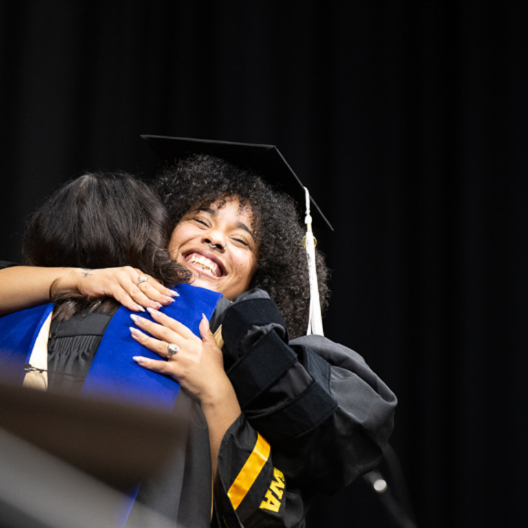 Graduates hugging at spring 2024 commencement 