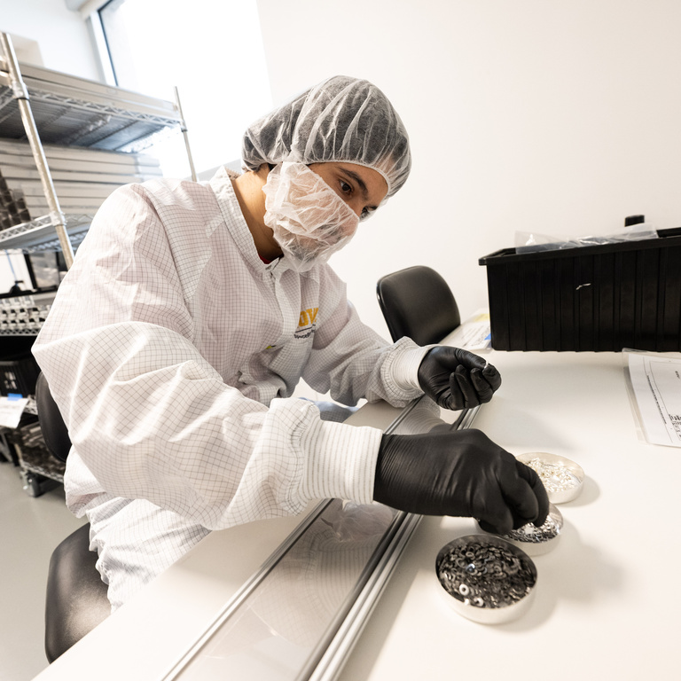 UI graduate student Halit Bagdu selects washers for electrical protective boxes that students have assembled for DUNE, an international effort to study neutrinos, a highly elusive particle that could explain how the universe formed and how it’s evolved.