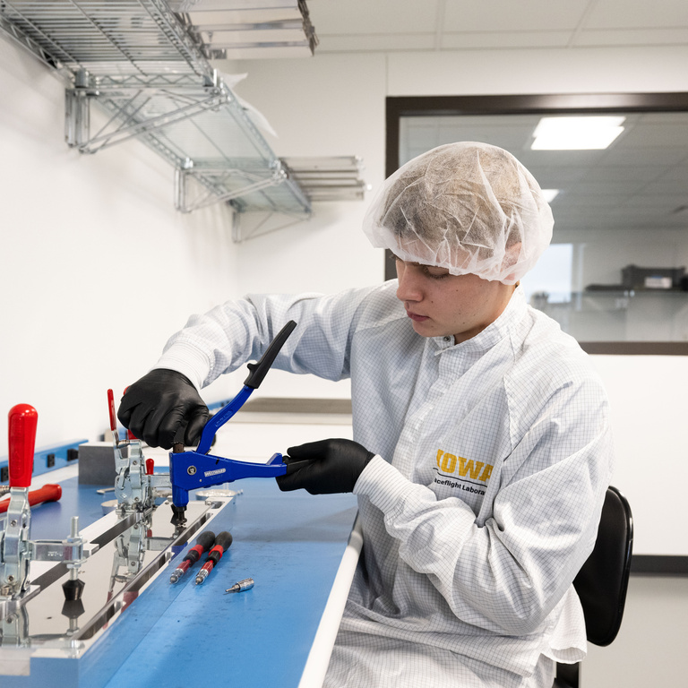 Luke Westendorf, a physics major from Downers Grove, Illinois, secures a bolt for the electrical protective boxes that will be part of the DUNE experiment, an international effort to study neutrinos, a highly elusive particle that could explain how the universe formed and how it’s evolved.