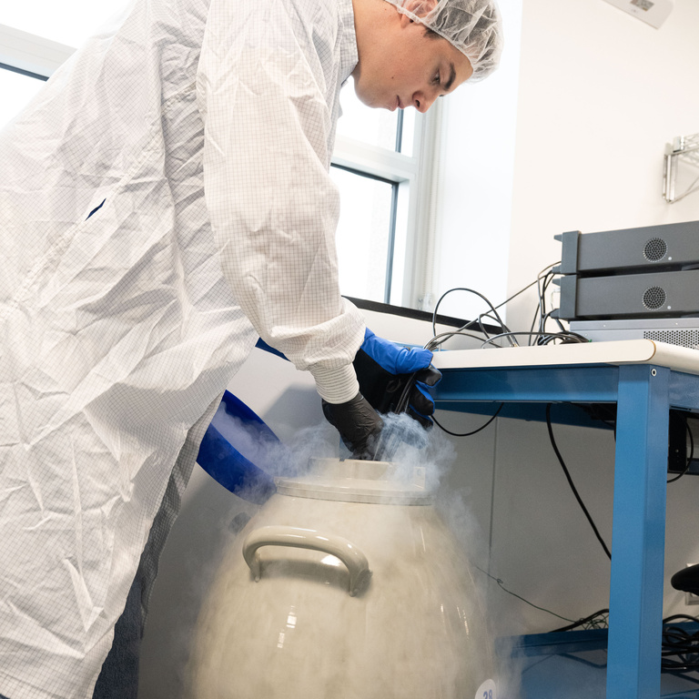 Nikolas Vinovich, a physics and statistics major from Lakeville, Minnesota, inserts an electronics circuit board into liquid argon, which is chilled (in liquid form) at -300 degrees Fahrenheit. The circuit boards assembled by UI students must withstand frigid temperatures to power a photon (particles of light) detector that is central to the DUNE experiment.