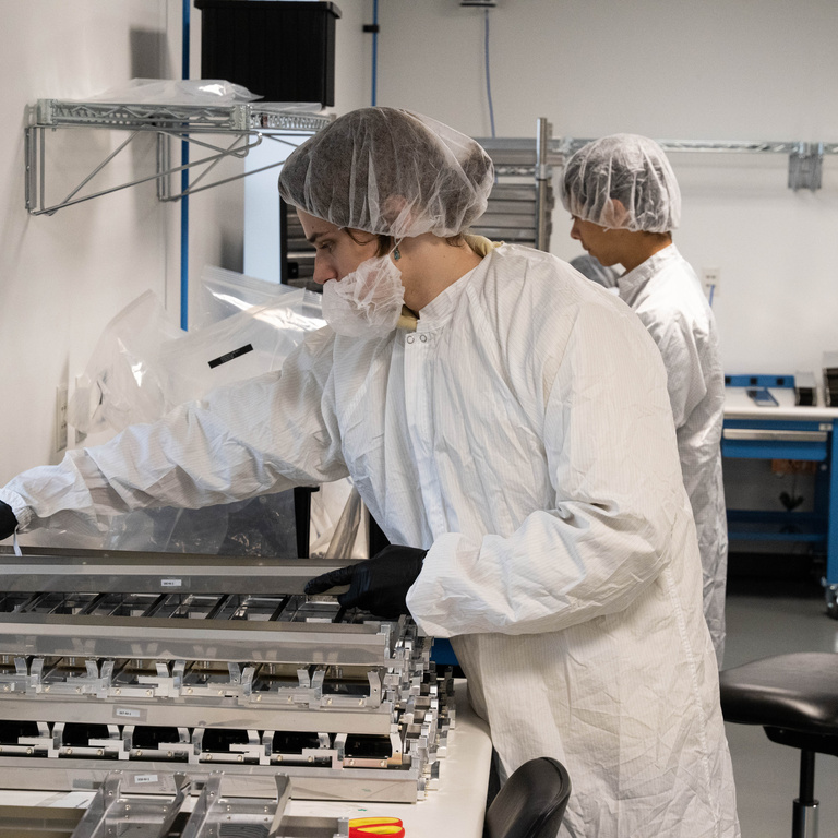 Alizhan Ryssaliyev, a physics and astronomy major from Almaty, Kazakhstan, prepares electrical protective boxes for shipping. The boxes will house electronics circuits boards, assembled by UI students, that will supply power to a photon (particles of light) detector for the DUNE experiment, an international effort to study neutrinos, a highly elusive particle that could explain how the universe formed and how it’s evolved.