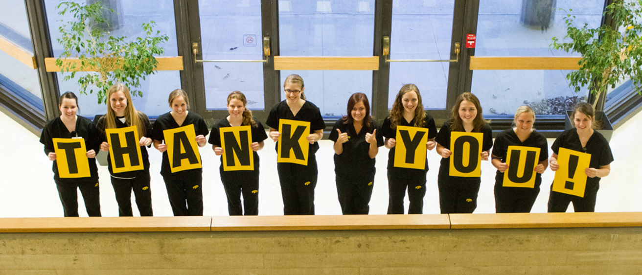 UI College of Nursing students hold up a thank you sign in front of the college.