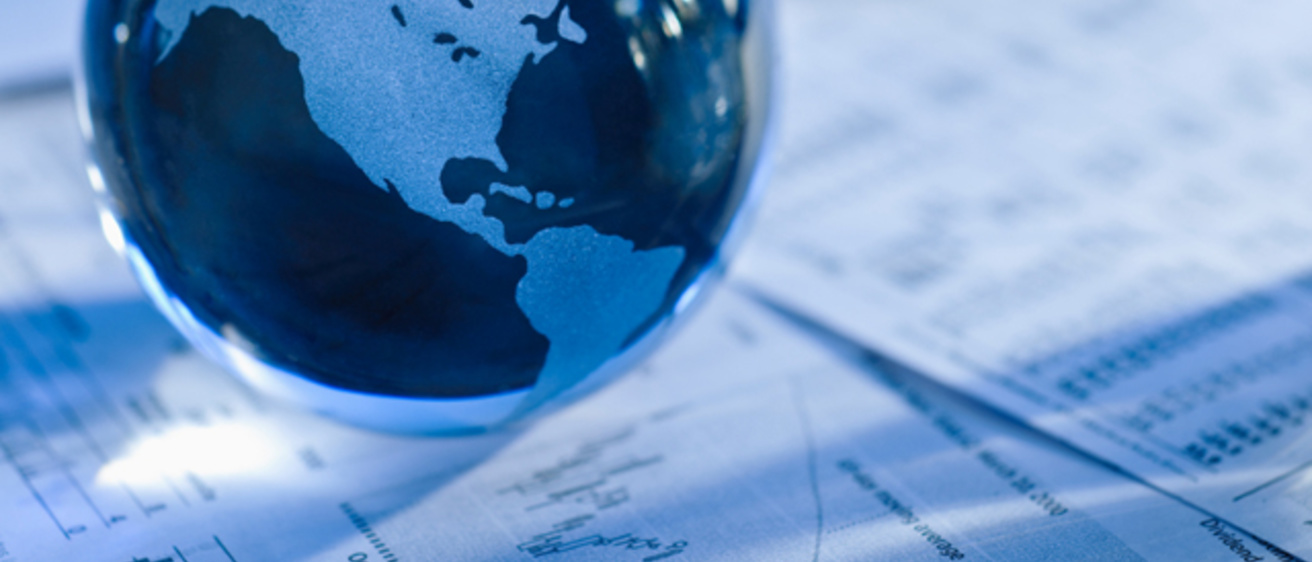 a globe sits on financial papers
