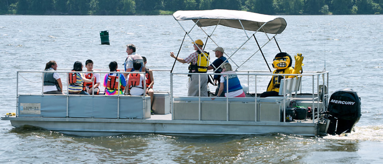 students, researchers, and Herky on pontoon