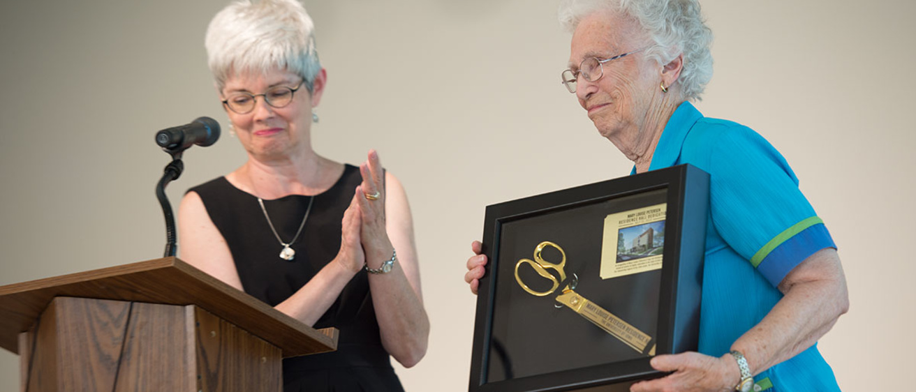 UI Foundation President Lynette Marshall presents Mary Louise Petersen with a framed memento during yesterday's dedication.