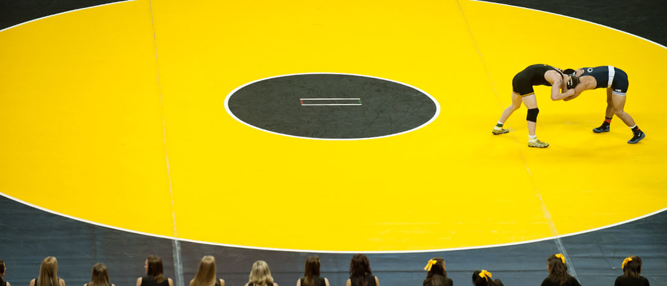two wrestlers on gold IOWA mat