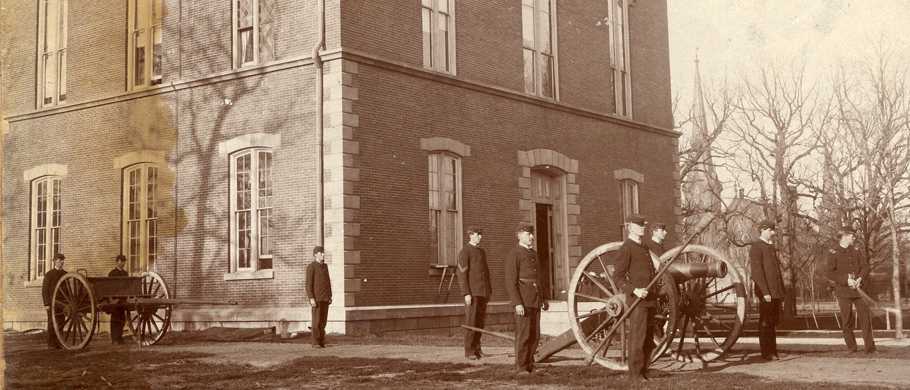 Historic photo of soldiers with cannon on central campus