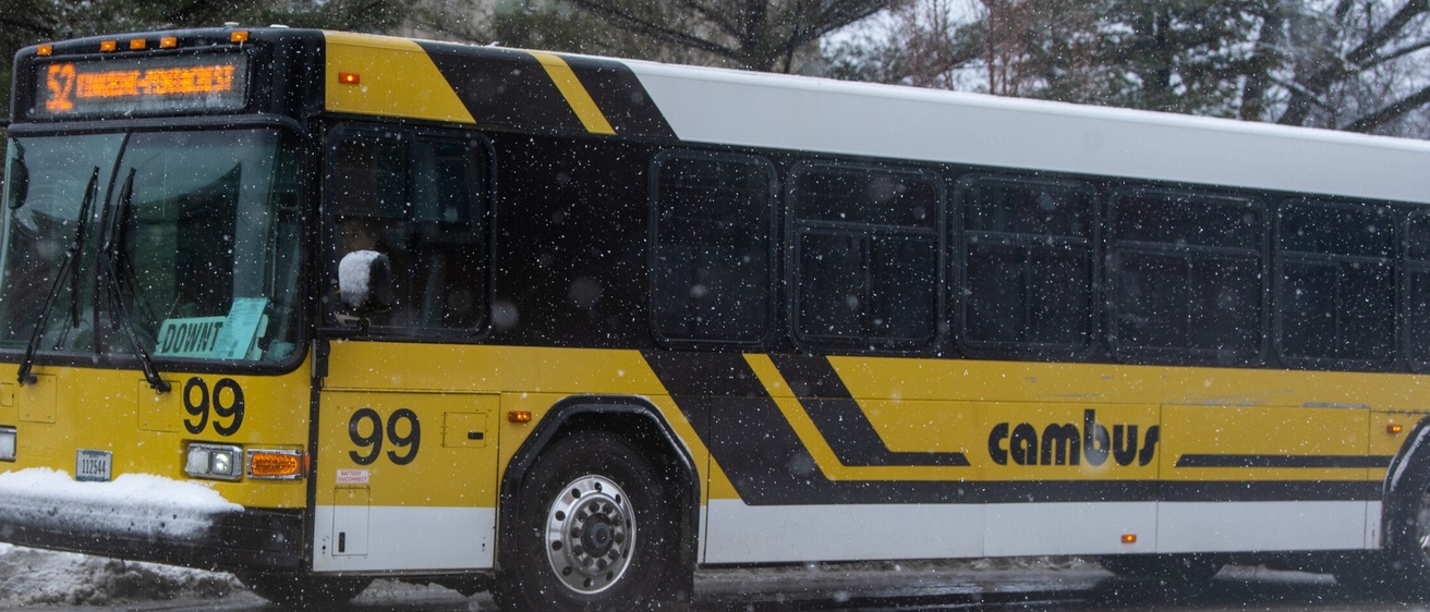 A yellow and white Cambus bus on a snowy day