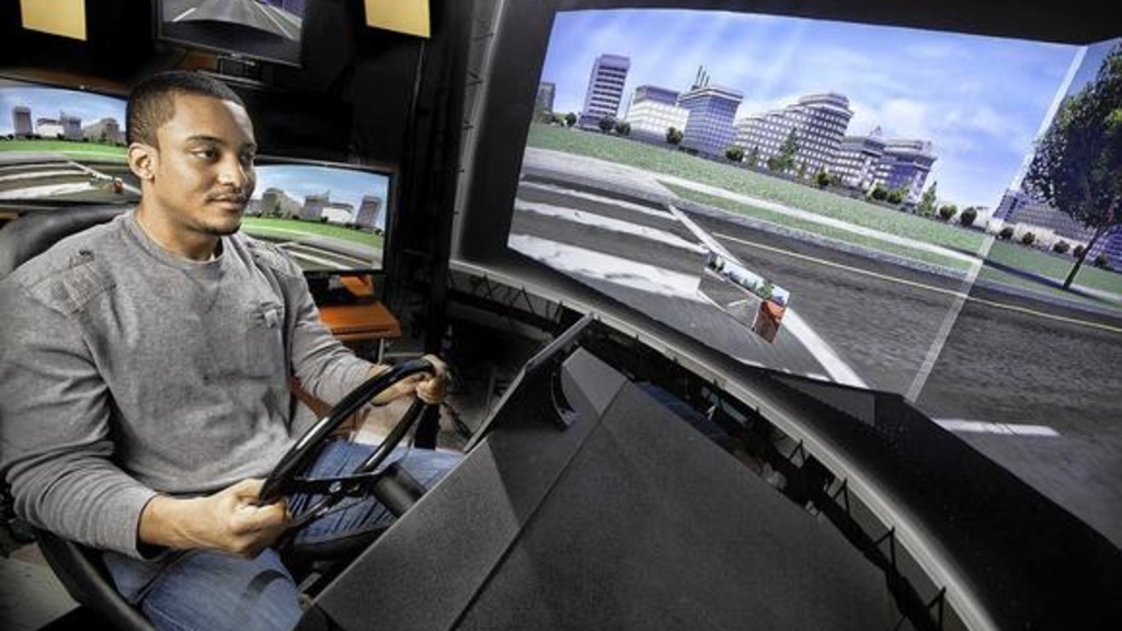 A man drives a vehicle in the UI's National Advanced Driving Simulator