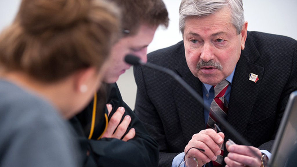 Governor Branstad works with students.