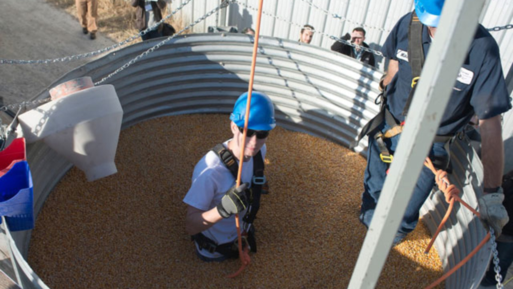 a man stands waist deep in corn during a grain safely conference