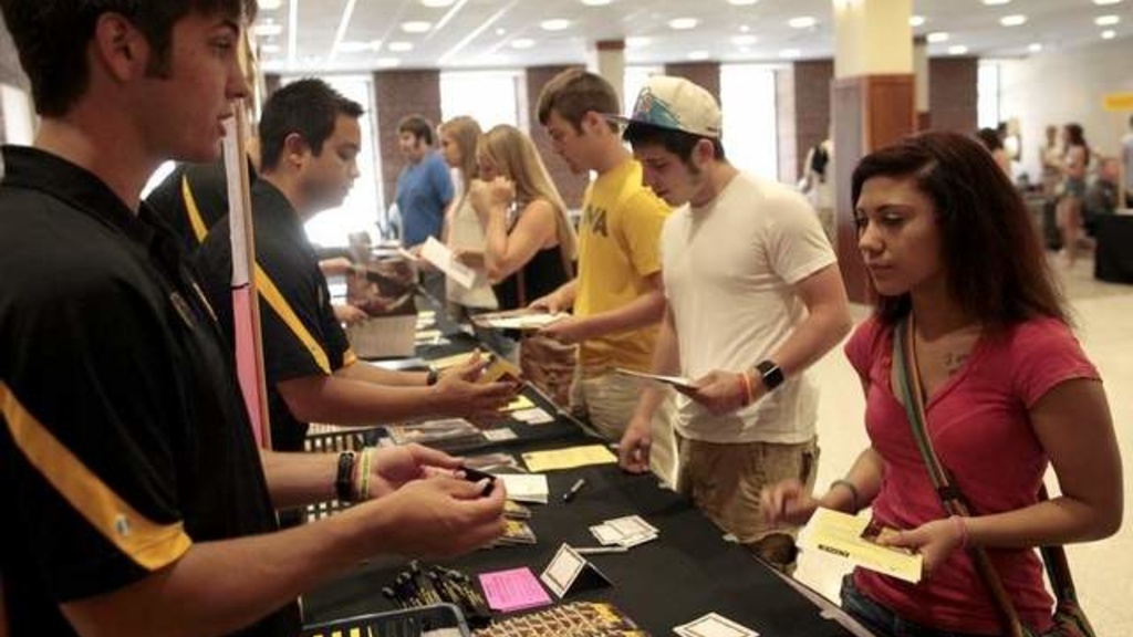 Incoming UI freshman Brianne Avery gets a flash drive wristband with information during orientation.