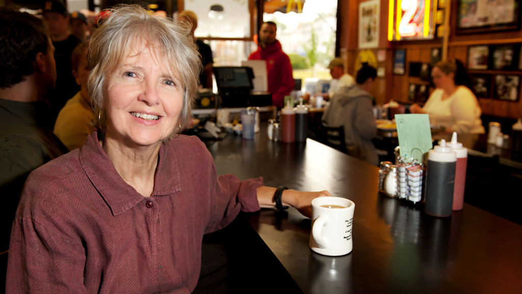UI alumna and bookmaker Marybeth Slonneger sits at the counter of the Hamburg Inn No. 2 in Iowa City.