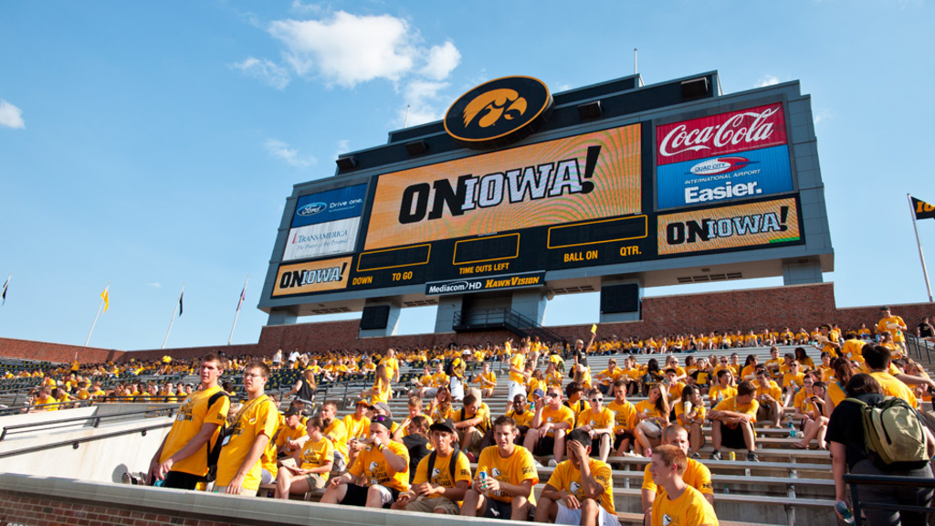 Students sitting in stands at Kinnick Stadium during On Iowa celebration