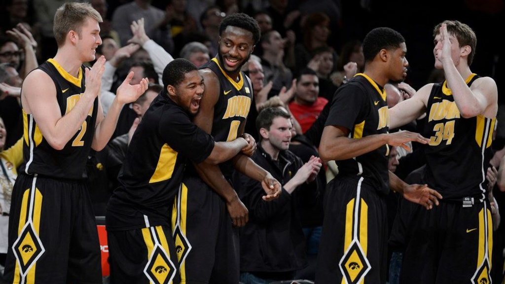 Men's basketball players celebrate a victory over Maryland