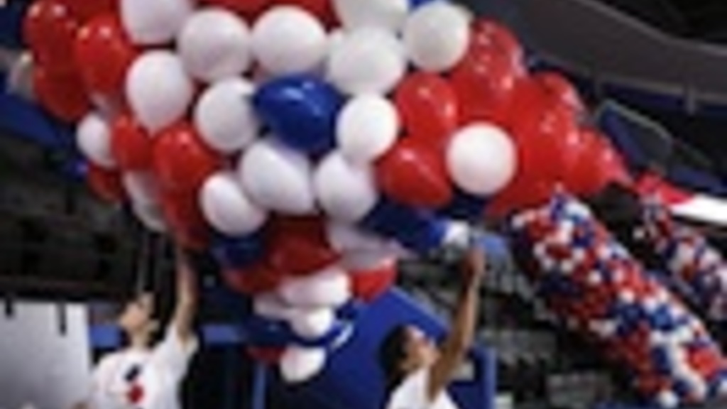 Setting up balloon drop in an arena. Photo by Kathleen Flynn, Tampa Bay Times, from linked story.