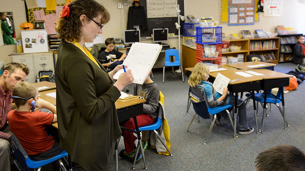 UI students stands in elementary school classroom