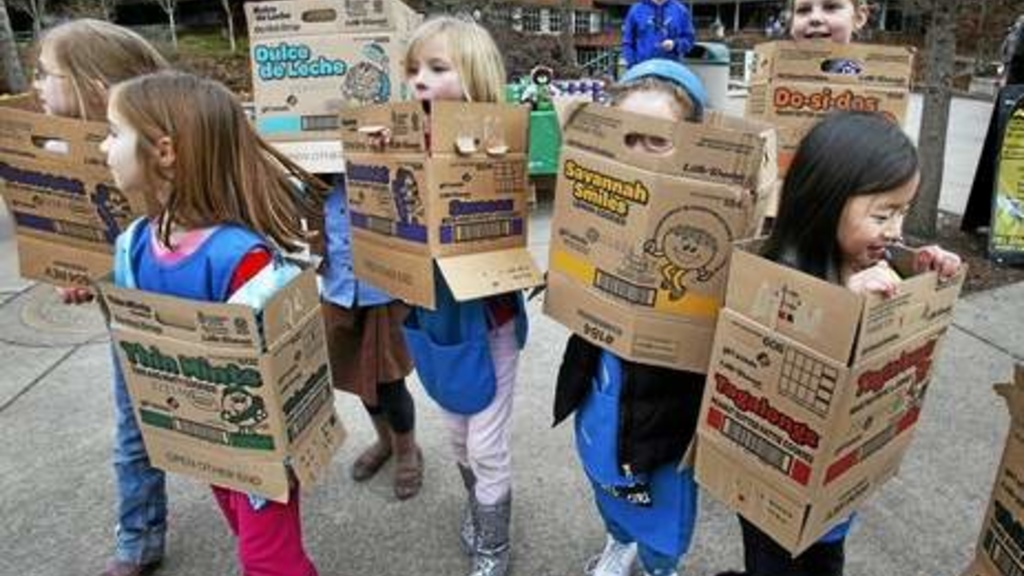 In a Feb. 18, 2013 file photo, dressed in boxes emptied from earlier cookie sales, Girl Scouts from Troop 20337 in Eugene fan out on the University of Oregon campus near the Erb Memorial Union in Eugene, Ore., in search of customers for their cookies.