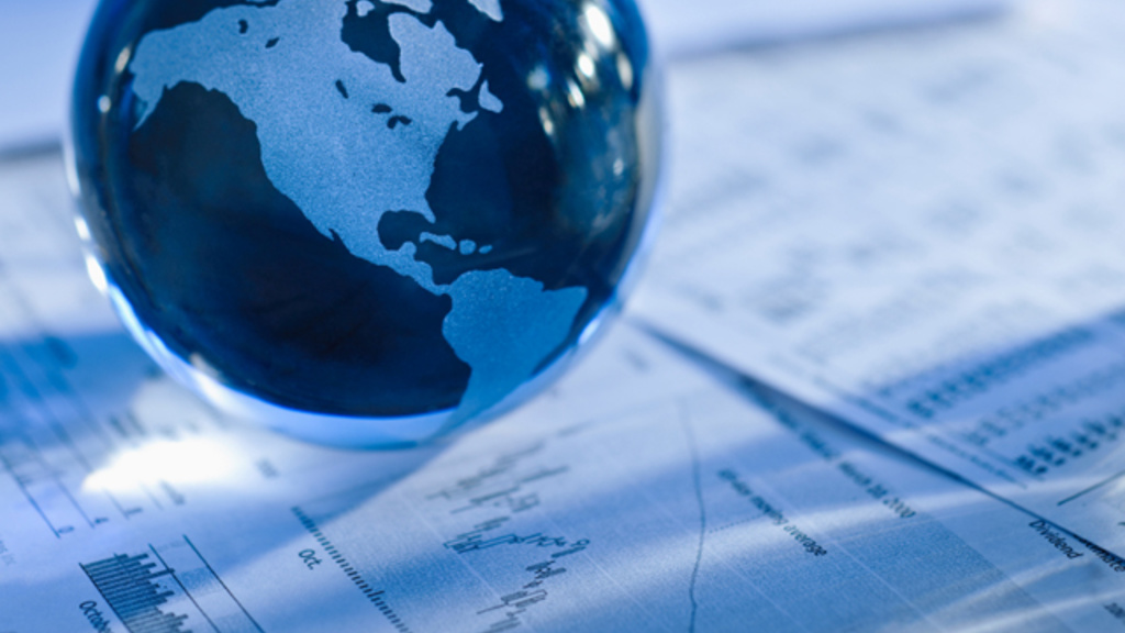 a globe sits on financial papers