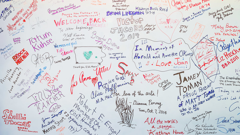 A white background with colored writings, including signatures and drawings made in marker