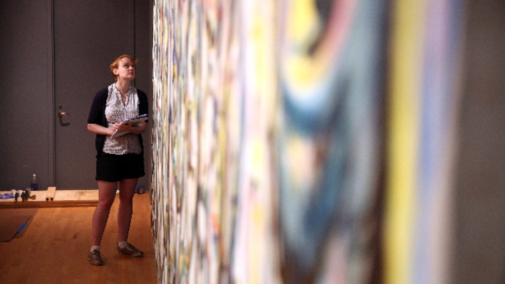 curator inspects Pollock's Mural
