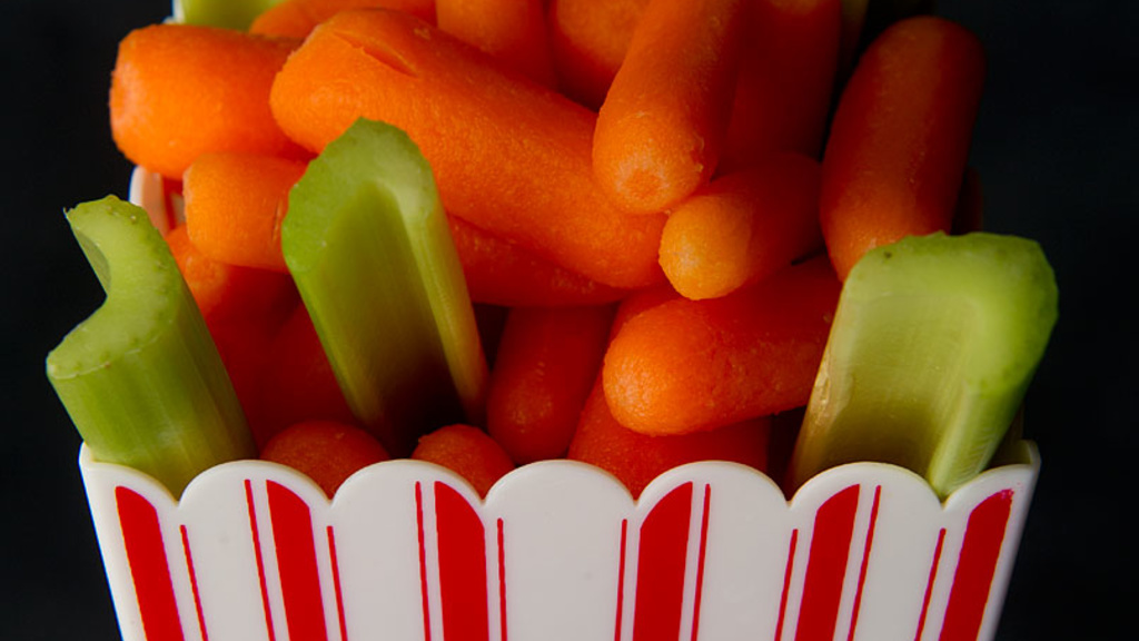 baby carrotts and celery sticks in a popcorn concession tray