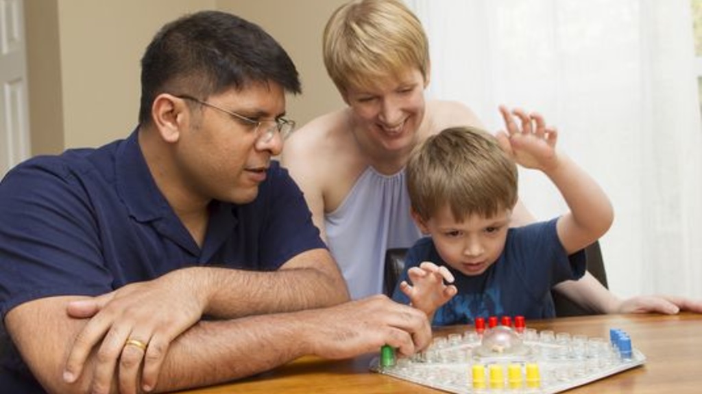 Cheeni Rao spends time with his wife and son, playing a game while sitting at a table