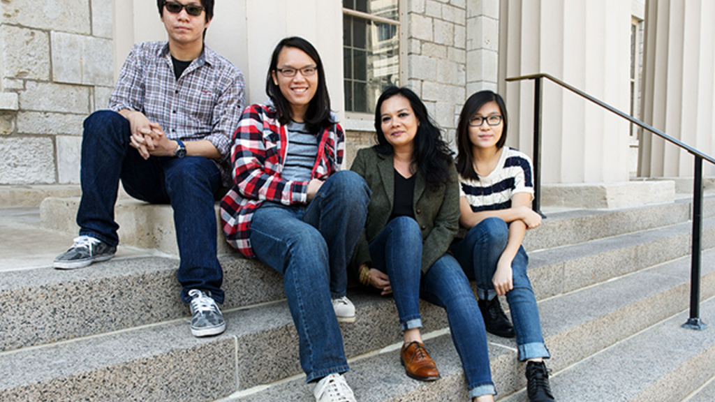 students sitting with their former teacher on old capitol steps
