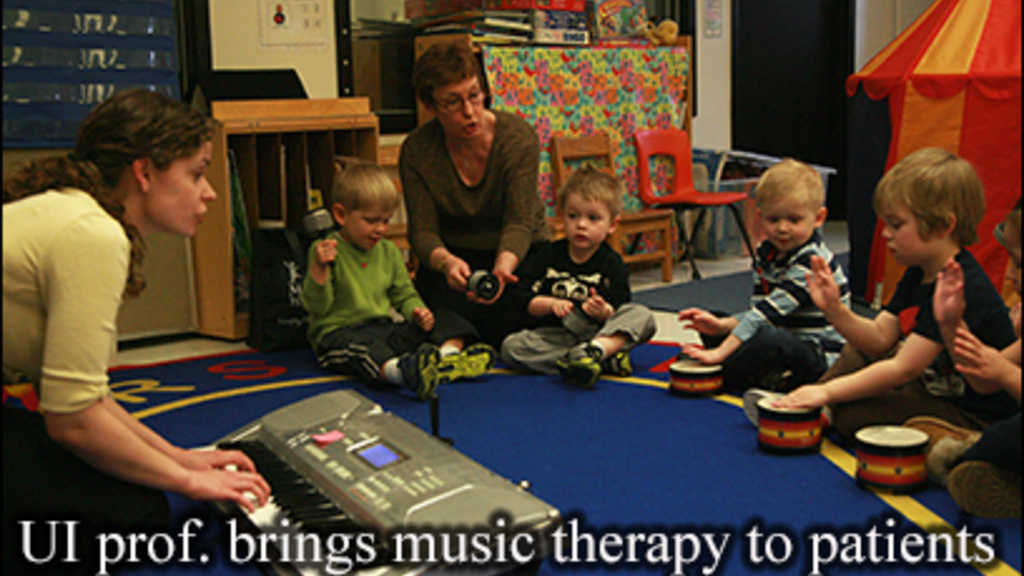 UI professor works with a group of young children using music therapy