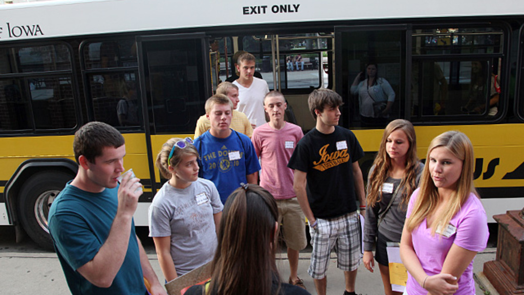 A group of students listens to an orientation guide