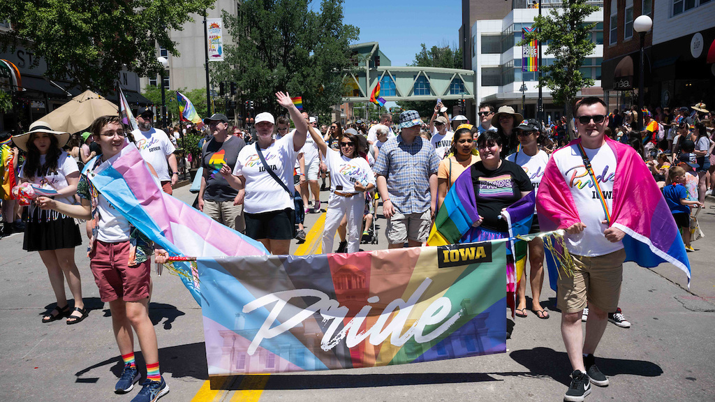 Parade leaders march down Linn Street during the 2022 Iowa City Pride Parade.