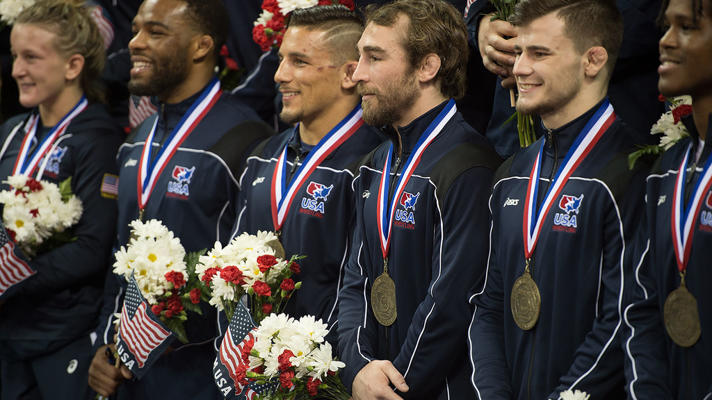 Daniel Dennis is surrounded by his Olympic teammates during the official team photo following the competition on Sunday.