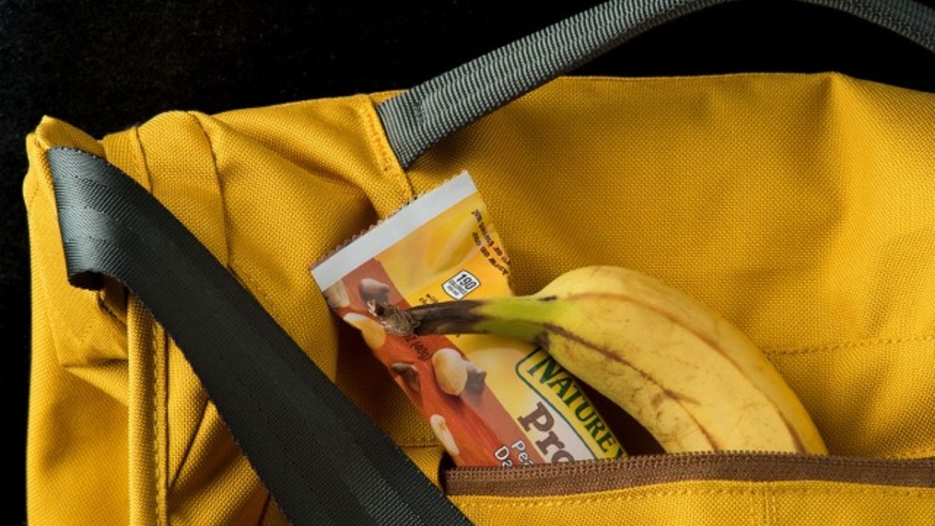 Bookbag with breakfast bar and banana spilling out of it.