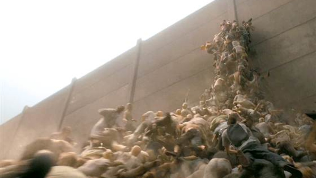A scene from the movie &quot;World War Z&quot; that shows people trying to escape over a wall to get away from zombies. Image courtesy of Paramount