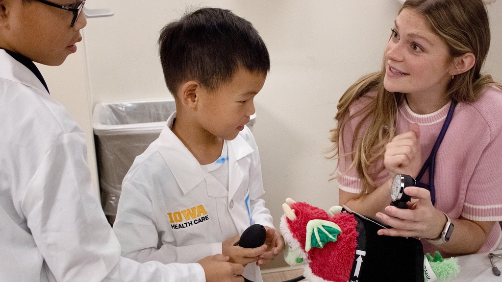 Reese Rosenmyer, CRISP scholar, talks with kids during Teddy Bear Clinic. Children pretend to be doctors to stuffed animals.