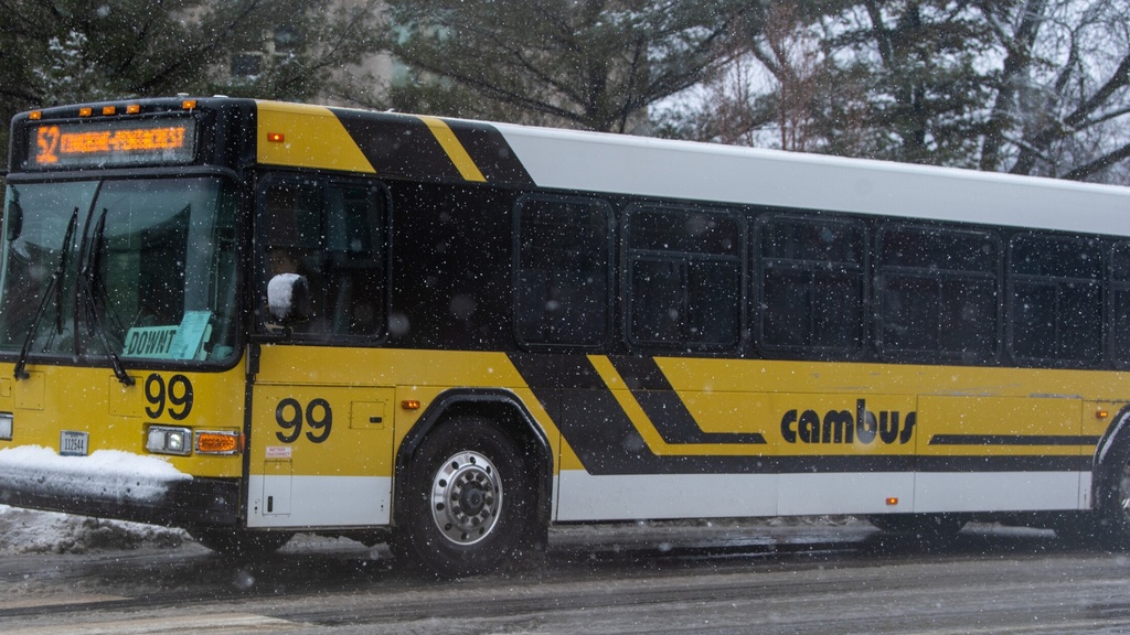 A yellow and white Cambus bus on a snowy day