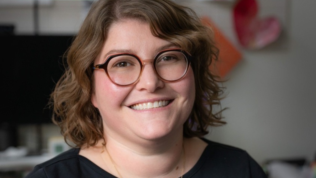 Allison Levine, assistant professor of counselor education in the College of Education. A woman with short, light brown, curly hair, wearing round brown and peach-colored glasses.