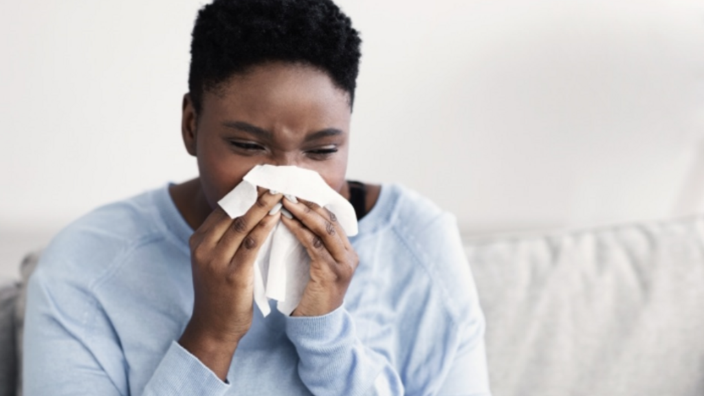 A person blowing their nose into a tissue